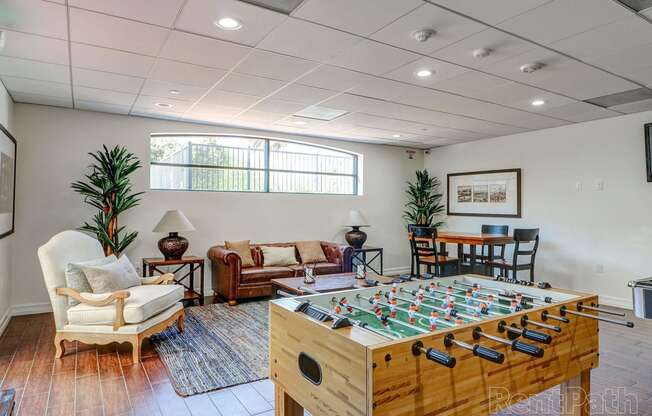 a game room with a foosball table and chairs