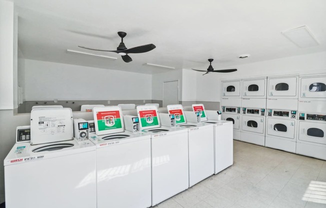 A row of white dishwashers are lined up in a store.