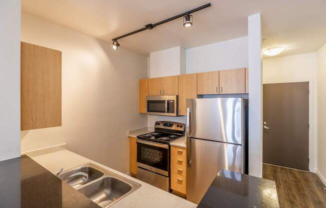 A modern kitchen with stainless steel appliances and wooden cabinets.