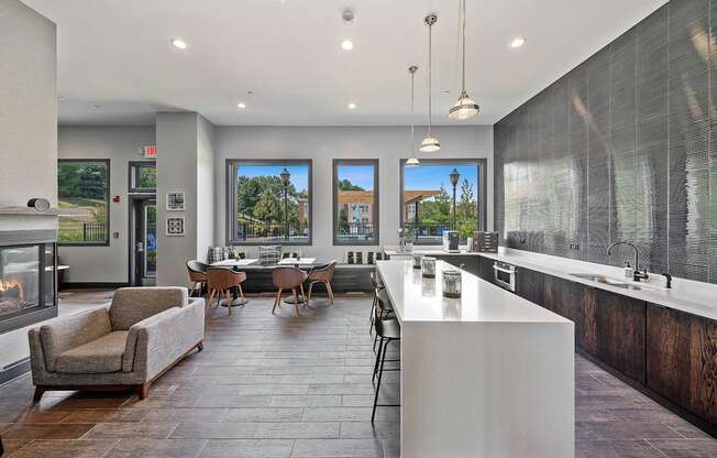 A modern kitchen with a large island and a dining table with chairs.