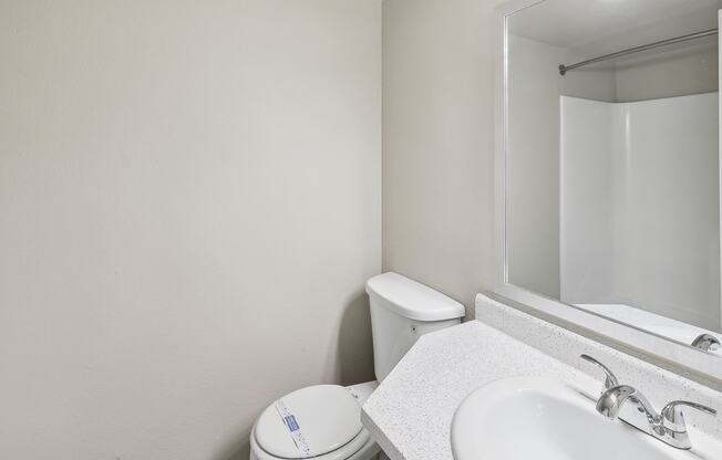 a bathroom with a sink toilet and a mirror