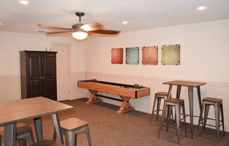 a game room with a shuffleboard table and bar stools at Walnut Trail Apartments, Portage