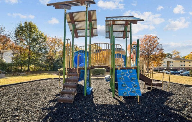 A playground with a blue slide and a brown wooden structure.