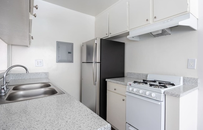 an empty kitchen with a stove refrigerator and sink