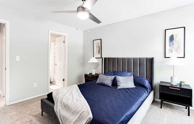 A bedroom with a bed, nightstand, and a ceiling fan.