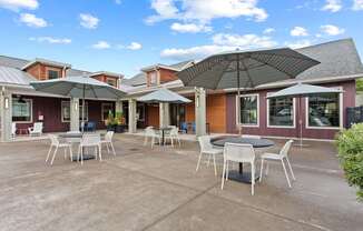 A patio with a table and chairs under an umbrella.