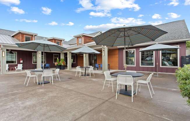 A patio with a table and chairs under an umbrella.