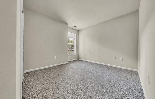 an empty room with carpet and a window