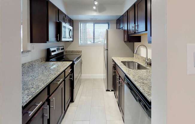 A kitchen with granite countertops and stainless steel appliances.