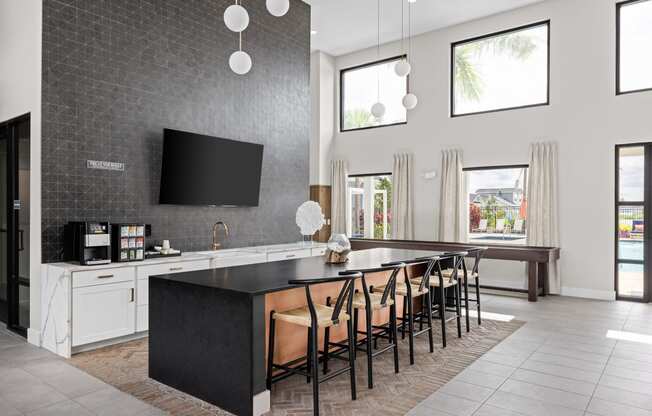 a large kitchen with a large island with chairs and a tv at The Sophia, Venice, FL, 34275