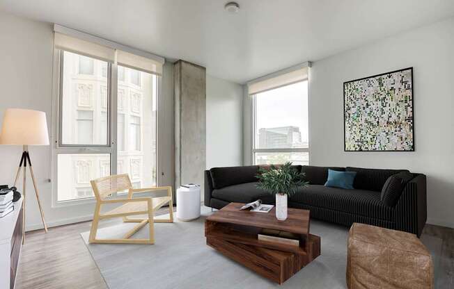 Open living room at Vance in San Francisco, CA.ch, wooden coffee table, and a large window.