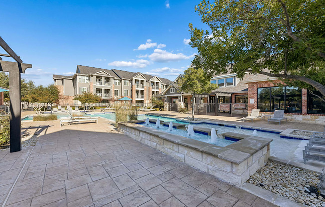 A large building with a pool in front of it.