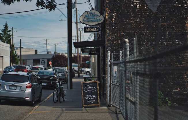 A street view of a parking lot with cars and a sign that says