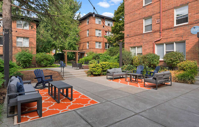 A patio with a table and chairs surrounded by a brick building.