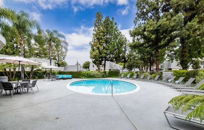 pool and hot tub with chaise lounge chairs and umbrella