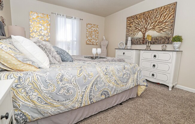 A bedroom with a bed, nightstand, and a painting on the wall at The Drake in Bossier City, LA