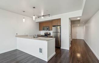 A kitchen with a white counter and a stainless steel refrigerator.