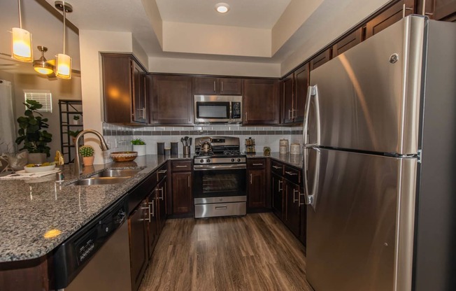 Kitchen with appliances and wooden cabinets1 at Level 25 at Cactus by Picerne, Las Vegas, 89141