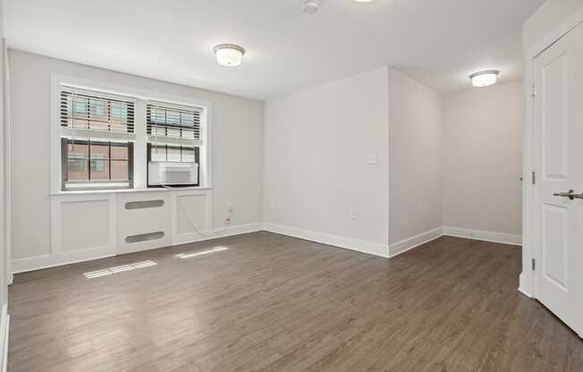 a bedroom with hardwood floors and white walls