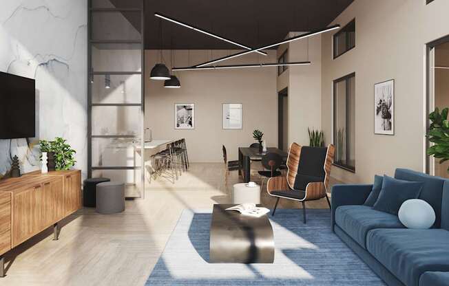 A modern living room with a blue sofa and a TV on the wall.