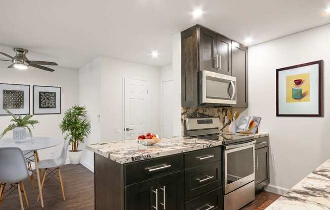 Beautiful Kitchen with Stainless steel electric range over micro hood microwave, dining area with ceiling fan