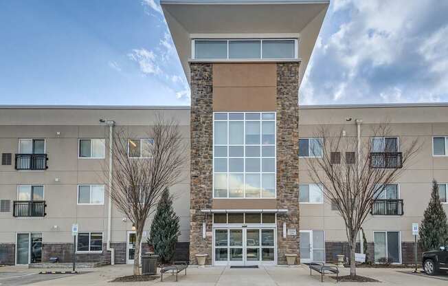 A modern building with a stone pillar in the center of the entrance.
