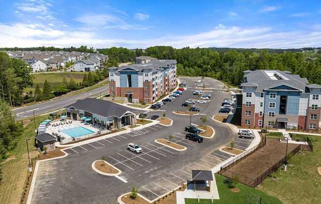 A large building complex with a pool and parking lot.