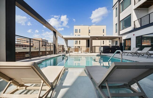 the pool area of a building with a swimming pool and lounge chairs  at The Box, Virginia, 23224