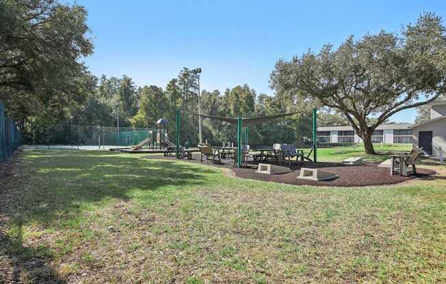 A park with a playground and picnic tables.