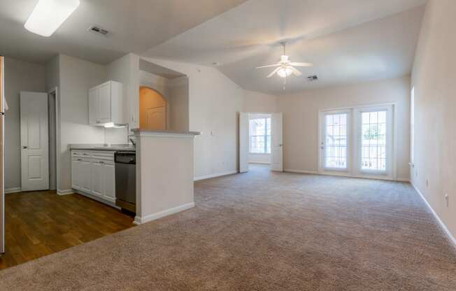 Living room with window light and ceiling fan and lights at Wynnewood Farms Apartments, Overland Park, KS