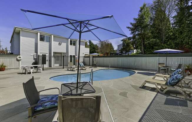 Cool Swimming Pool with Lounge Chairs and Shaded Bistro Table Set at Campo Basso Apartment Homes, Washington, 98087