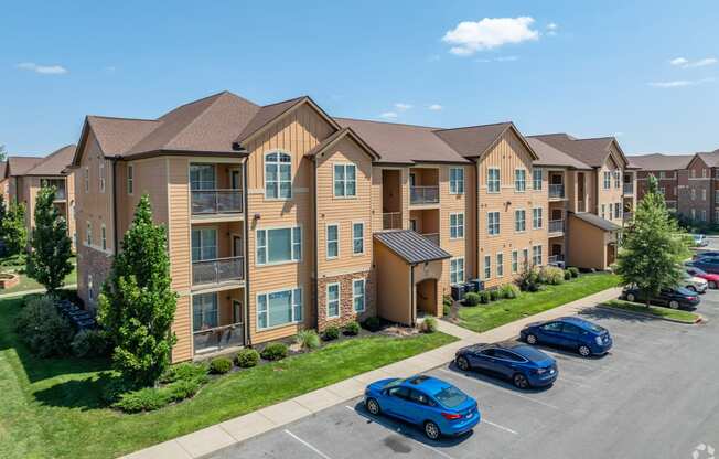 an apartment building with cars parked in a parking lot