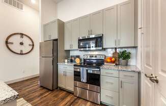 A kitchen with a stainless steel refrigerator, oven, and microwave.