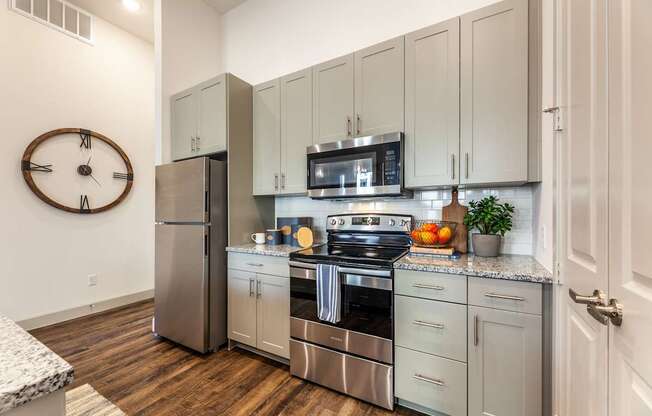 A kitchen with a stainless steel refrigerator, oven, and microwave.