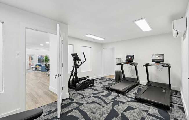 A room with treadmills and elliptical machines.