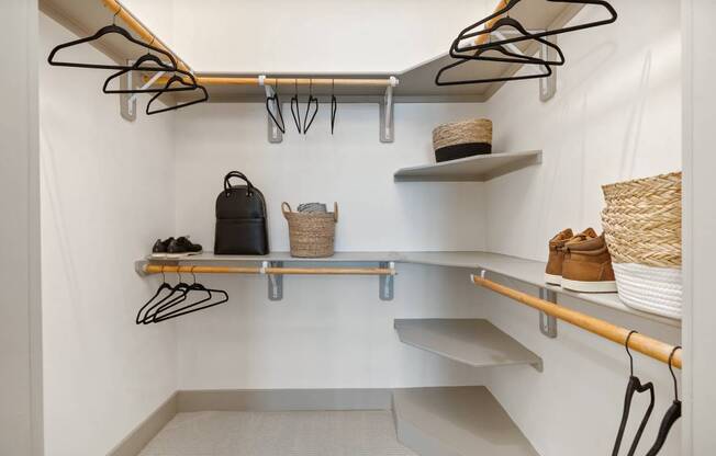 a walk in closet with shelves and hooks