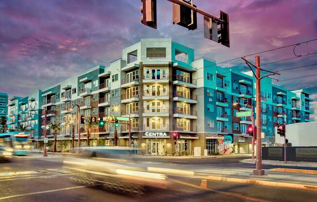 A street view of a city with a multi-story building with a sign that says "CENTRA" on it.