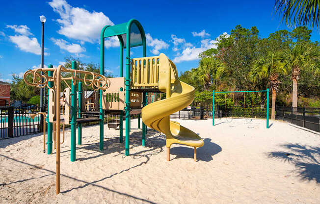 a playground with a large yellow slide in a park