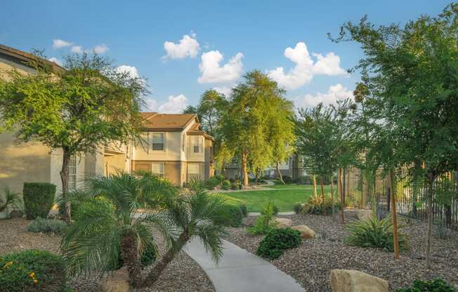 a courtyard with trees and a sidewalk in front of a building