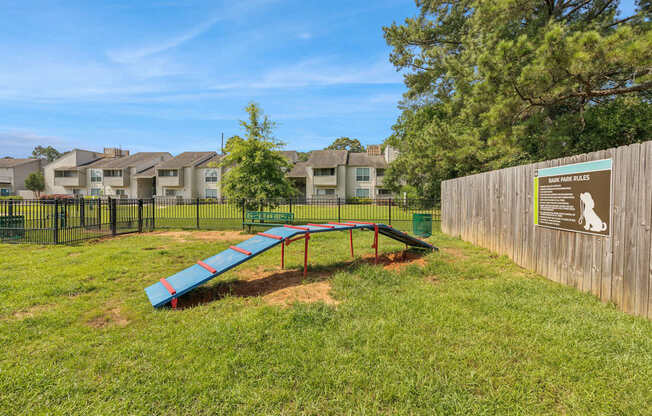 A playground with a slide and a sign on a fence.