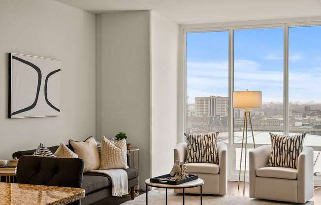 A living room with a large window overlooking a cityscape.