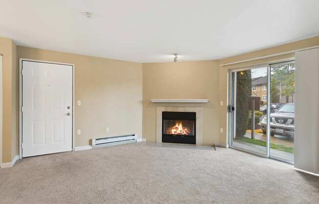 an empty living room with a fireplace and a glass door at Quartz Creek, Mountlake Terrace, Washington
