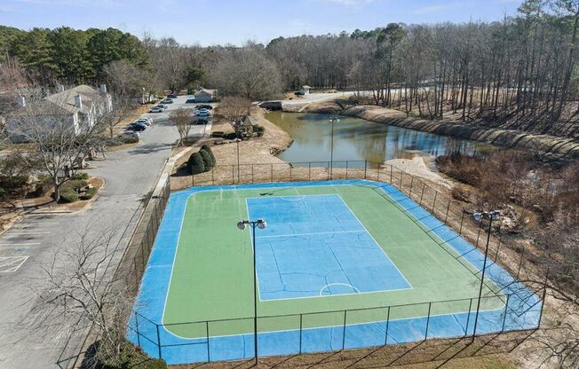 an aerial view of a blue and green tennis court    and a river