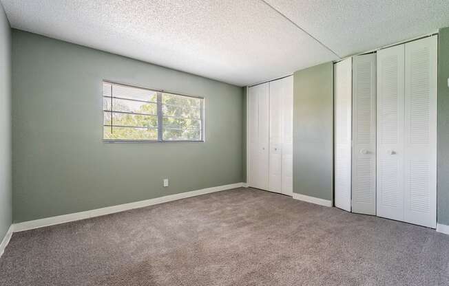 a bedroom with two closets and a carpeted floor at Bella Mar Apartments