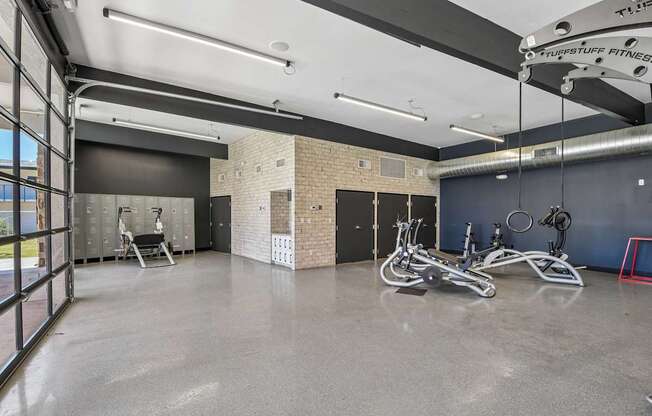 A gym with a brick wall and a variety of exercise equipment.
