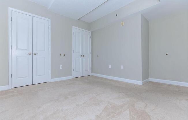 a bedroom with two doors and a carpeted floor