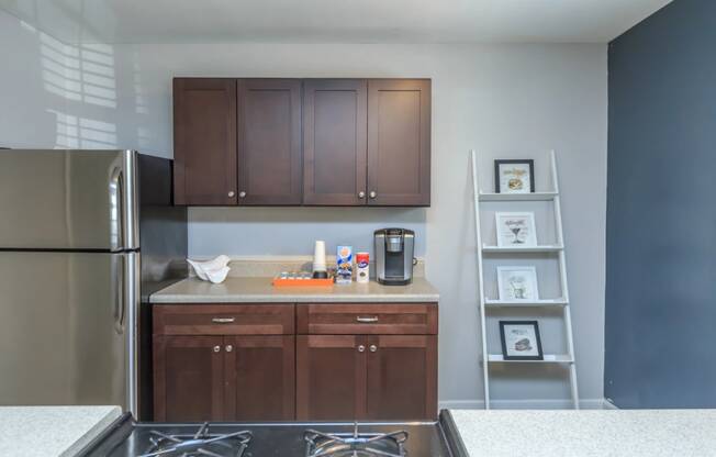 a kitchen with dark wood cabinets and a stainless steel refrigerator