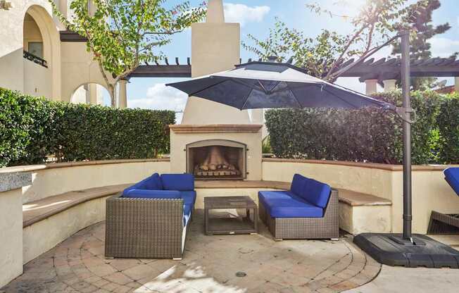 A patio with a fireplace and chairs.