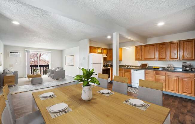 a dining area with a wooden table and chairs and a kitchen and living room in the background at Wildflower, Kennewick Washington