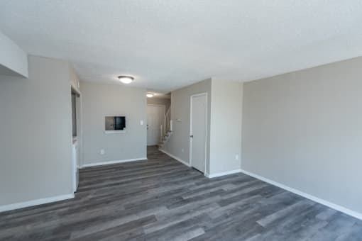 the spacious living room and hallway of an apartment